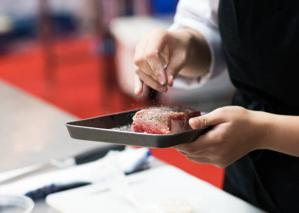 istock Chef salt and pepper meat  beef steak, cooking meat steaks on kitchen 1155163769