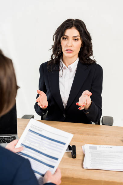 istock selective focus of attractive woman gesturing while talking with recruiter in office 1155163924