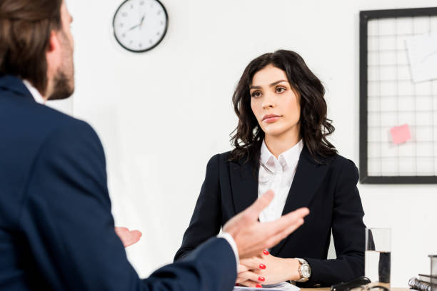 istock selective focus of attractive recruiter looking at man gesturing during job interview 1155163960