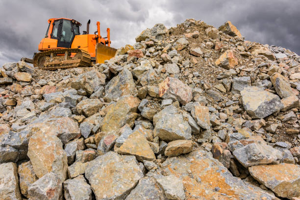 excavadora moviendo roca en una cantera - rock quarry fotografías e imágenes de stock