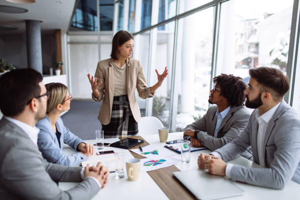 istock Female manager stands addressing team at board meeting 1155172755