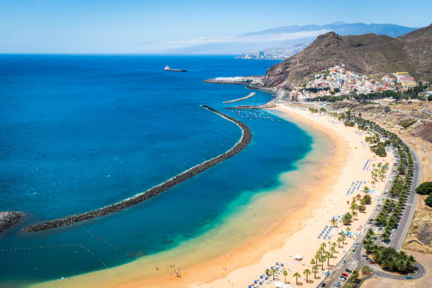 Beach of the Teresitas beach In the front - Playa de Las Teresitas beach and small village of San Andreas, in the back - part of Tenerife’s capital - Santa Cruz de Tenerife and Auditorio de Tenerife. Mountain Teide visible in the far back. tenerife stock pictures, royalty-free photos & images