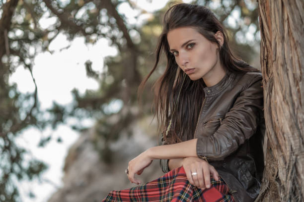 istock Young woman sitting on cliff and enjoy the view 1155174212