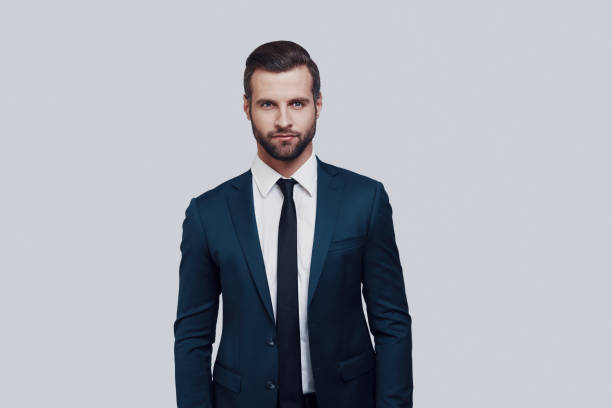 istock Perfect man. Handsome young man looking at camera while standing against grey background 1155175817