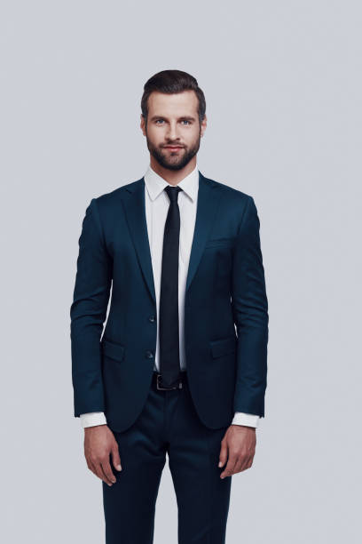 istock Portrait of confidence. Handsome young man looking at camera while standing against grey background 1155175872