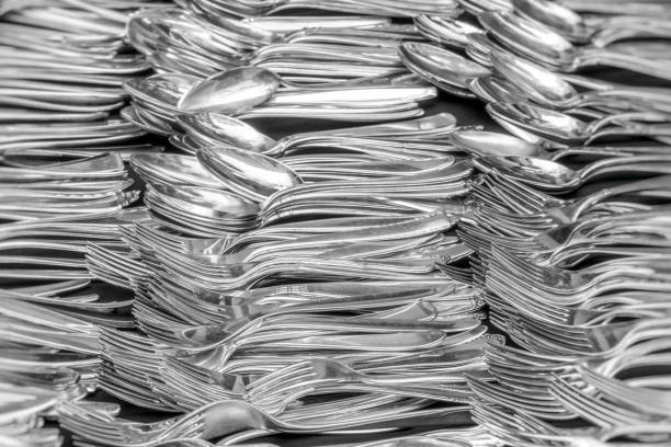 Close up image depicting the contents of the cutlery drawer - forks, knives, spoons - in a domestic kitchen.