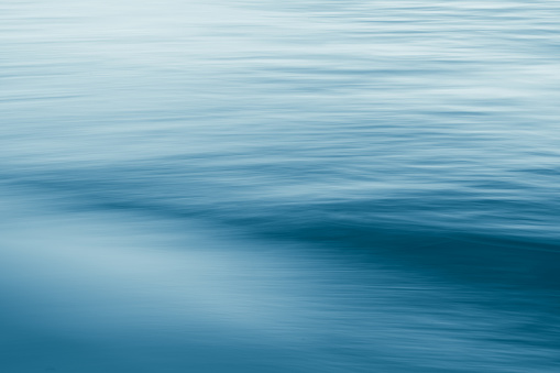 Long exposure blue water surface background.