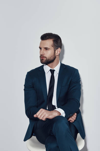 istock Quiet contemplation. Handsome young man looking away while sitting against grey background 1155178782