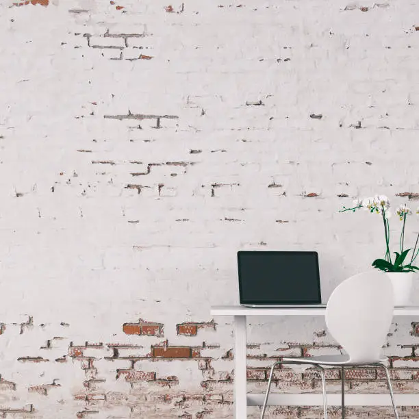 Workdesk with decoration in front of empty white brick ruined wall with copy space. 3D rendered image.