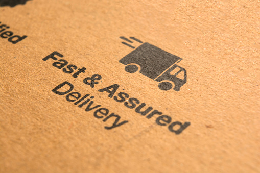 Fast and assured delivery concept printed on cardboard.