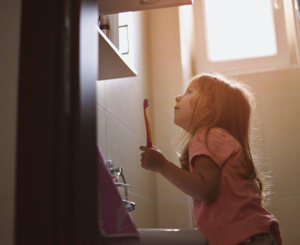 little girl brushing her teeth - hairstyle crest imagens e fotografias de stock