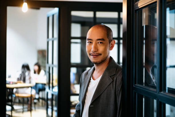 istock Cheerful Chinese man in corridor smiling at camera 1155183407