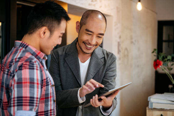 istock Mature businessman using tablet with young colleague 1155183435