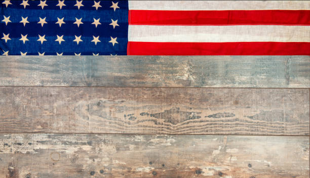 istock an American flag lying on an aged, weathered rustic wooden background. 1155183649