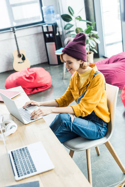 istock smiling young female it specialist using laptop in loft office 1155183771