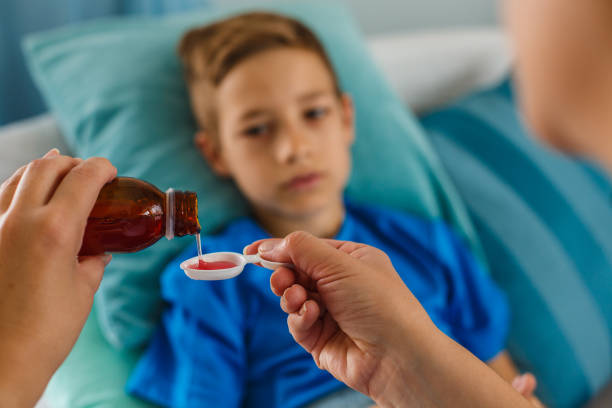 istock Woman pouring syrup for sick boy 1155184074