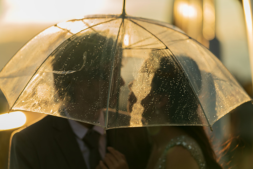 Charming couple walking outdoors in the city together on a rainy winter day.