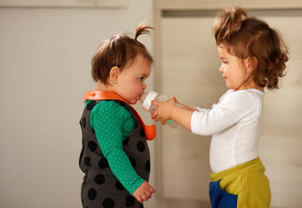 little girl giving to the other little girl water, fun time.