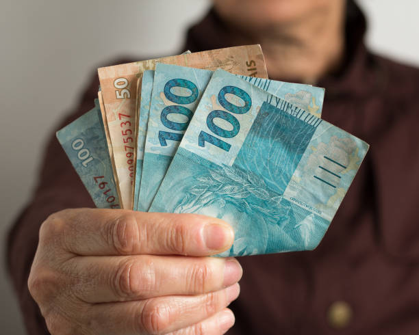 istock Midsection Of Man Holding Paper Currency 1155193180
