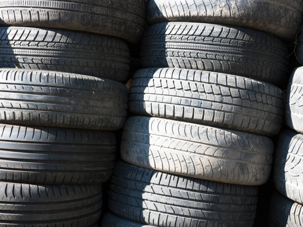 istock Old tires stacked one on another next to shop garage 1155193241