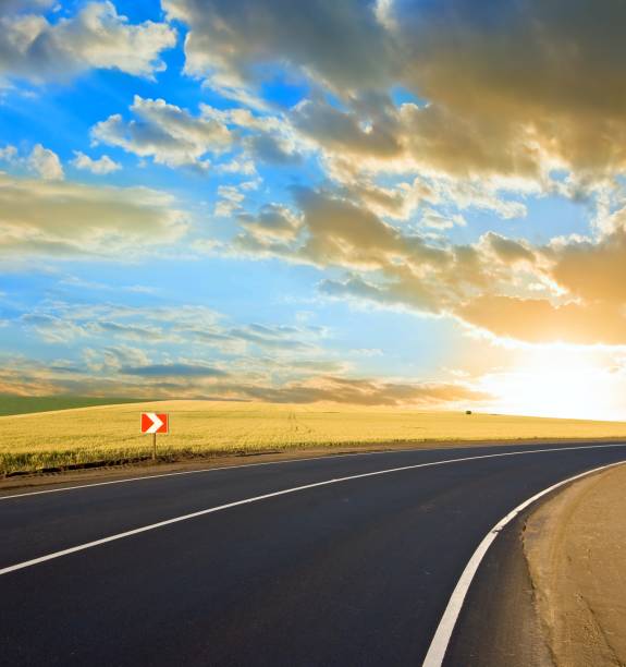 istock asphalt road turn at the sunset 1155195102