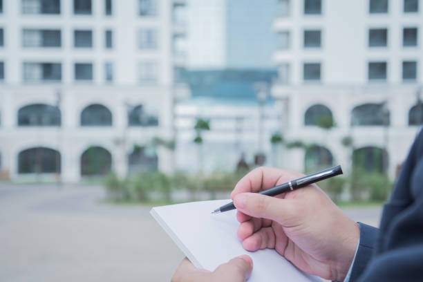 istock Close up Human Hand Signing on Formal Paper 1155201166