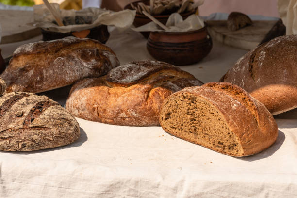 istock Large loaves of bread on a rustic background on a street counter. 1155201618