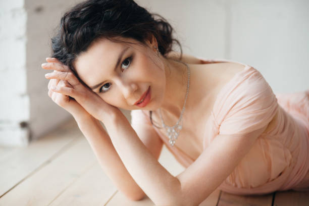 istock Young beautiful girl is lying on a wooden floor 1155201799