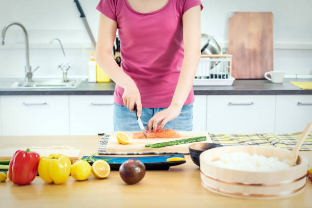 woman preparing sushi in domestic kitchen - sushi japanese culture food domestic kitchen imagens e fotografias de stock