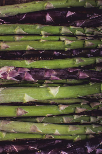 Raw Organic Asparagus in Juta Bag on Dark Wood Background