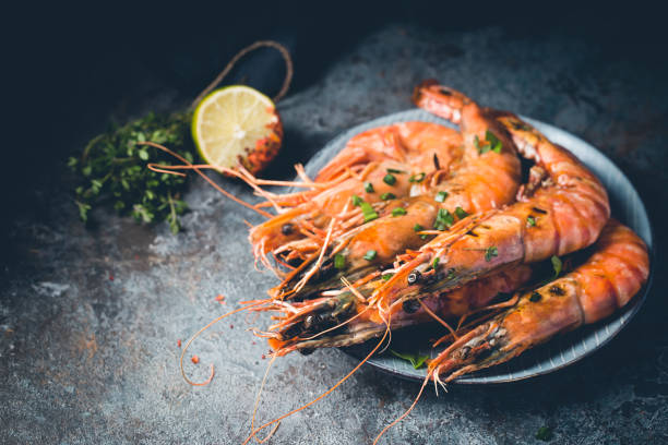 Fresh Tiger Prawns Giant fresh Tiger Prawns on plate over dark stone background black tiger shrimp stock pictures, royalty-free photos & images