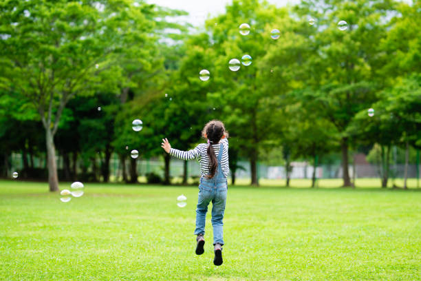 dziewczyna bawi się bańkami mydlanymi - lawn little girls small child zdjęcia i obrazy z banku zdjęć