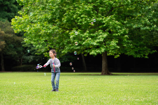 istock Girl playing with soap bubbles 1155203803
