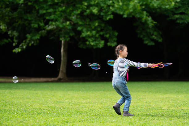 istock Girl playing with soap bubbles 1155203925