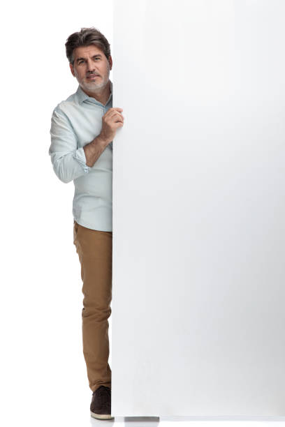 istock Casual man leaning and standing behind  blank board 1155204245