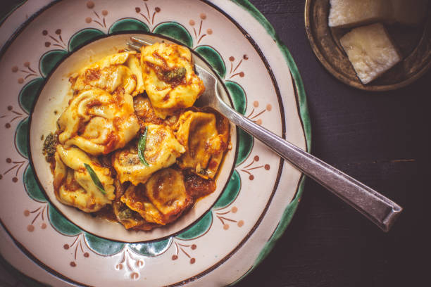 istock Tortellini with Tomato Sauce, Mozzarella Cheese and Basil on Rustic Plate 1155206722