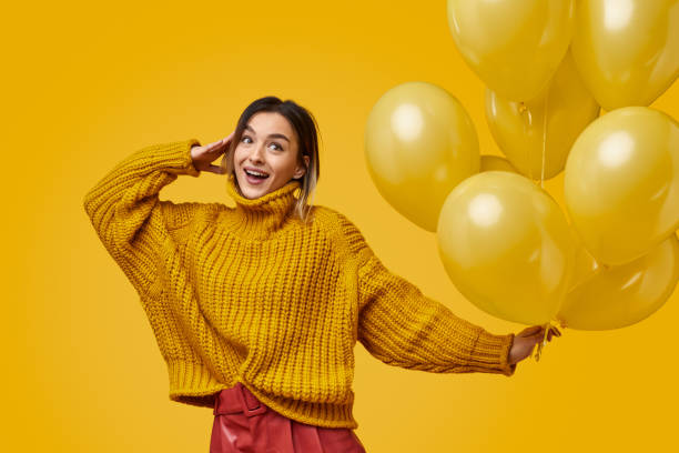 istock Cheerful woman with balloons saluting 1155208829