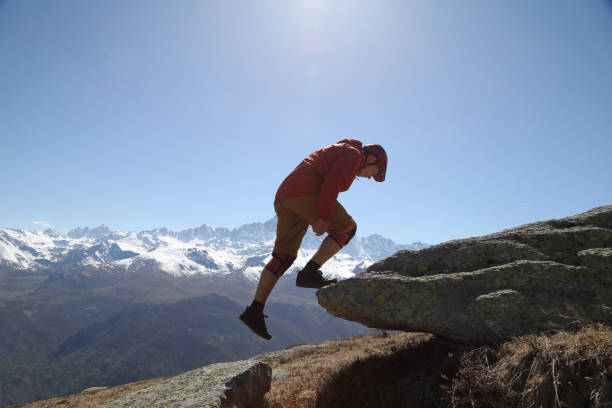 istock Male mountain biker steps up onto rock he plans on riding off 1155209287