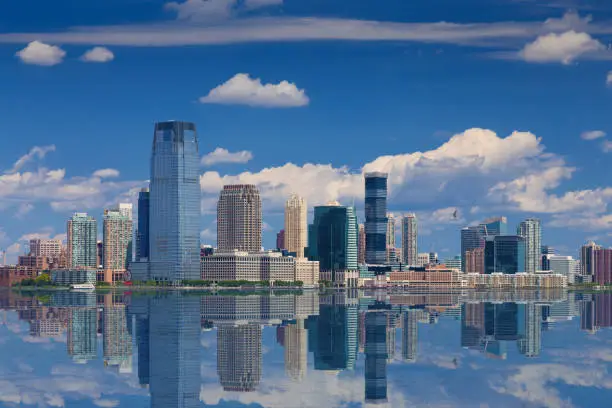 Photo of Jersey City Skyline with Goldman Sachs Tower Reflected in Water of Hudson River, New York, USA.
