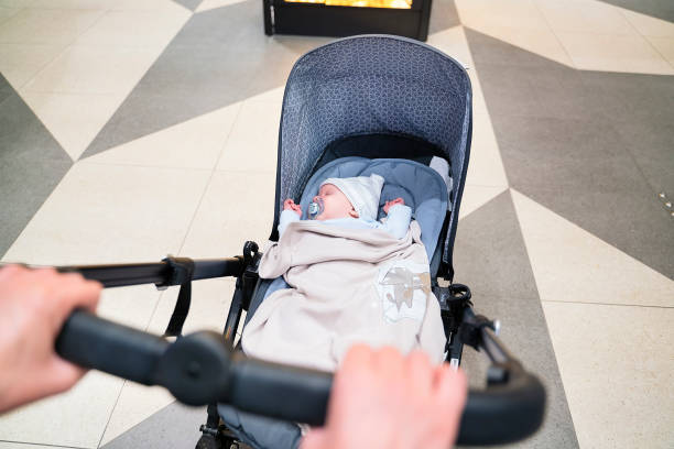 istock Pushing baby stroller on street - First person view 1155211811
