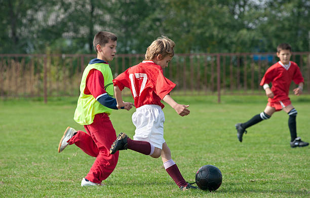 istock boy kicking football 115521248