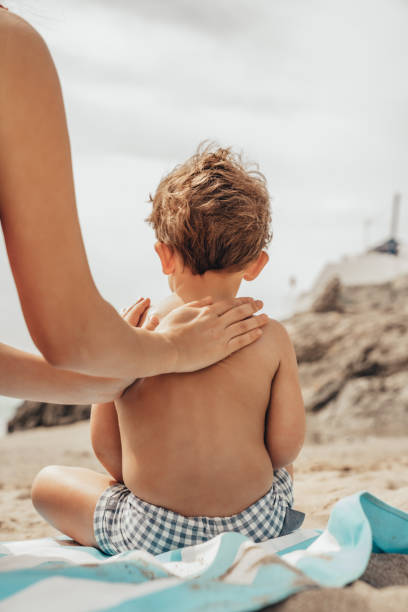 Mother applying sunscreen to her child