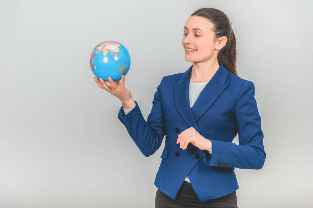 istock Young geography teacher holding a globe, looking at it, smiling. 1155213933