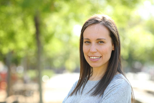 istock Happy woman looking at camera outdoors in a park 1155215330