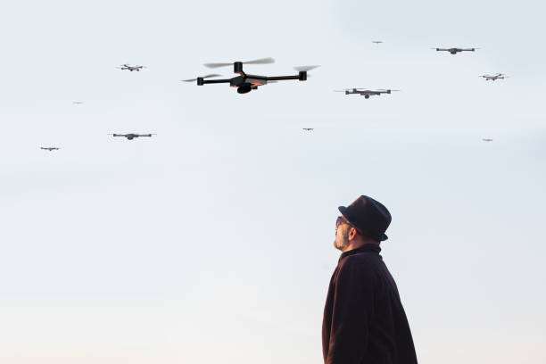 istock man looking at the sky full of drones 1155215339