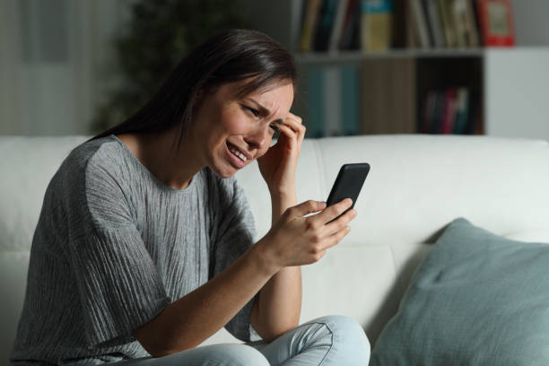 istock Sad woman at home checking smart phone in the night 1155215421