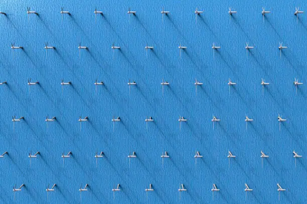 Photo of an aerial view of wind turbines in the ocean