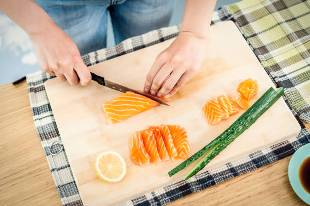 woman preparing sushi in domestic kitchen - sushi japanese culture food domestic kitchen imagens e fotografias de stock