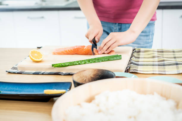 woman preparing sushi in domestic kitchen - sushi japanese culture food domestic kitchen imagens e fotografias de stock