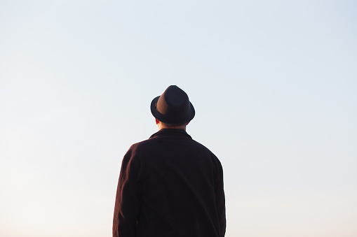 Man with hat looking at clear sky